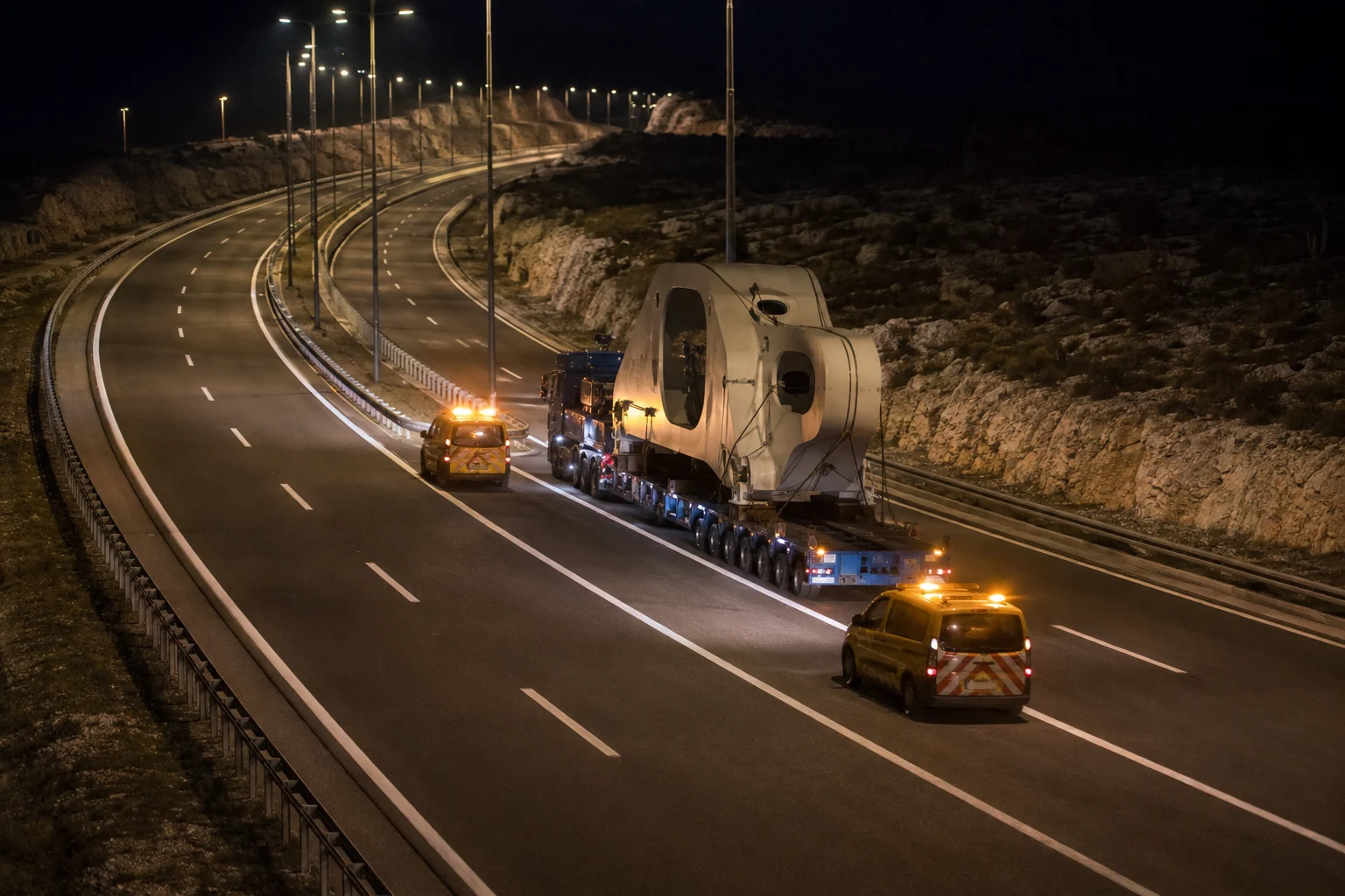 Ein begleiteter Schwertransport fährt nachts auf der kroatischen Autobahn A1
