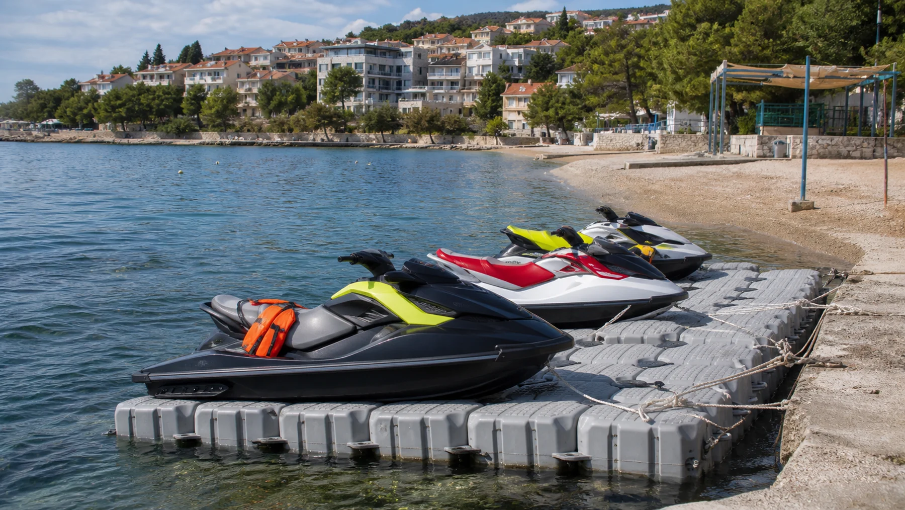 Unbenutzte Jet-Skis stehen auf einem Ponton neben einem öffentlichen Strand an der kroatischen Küste