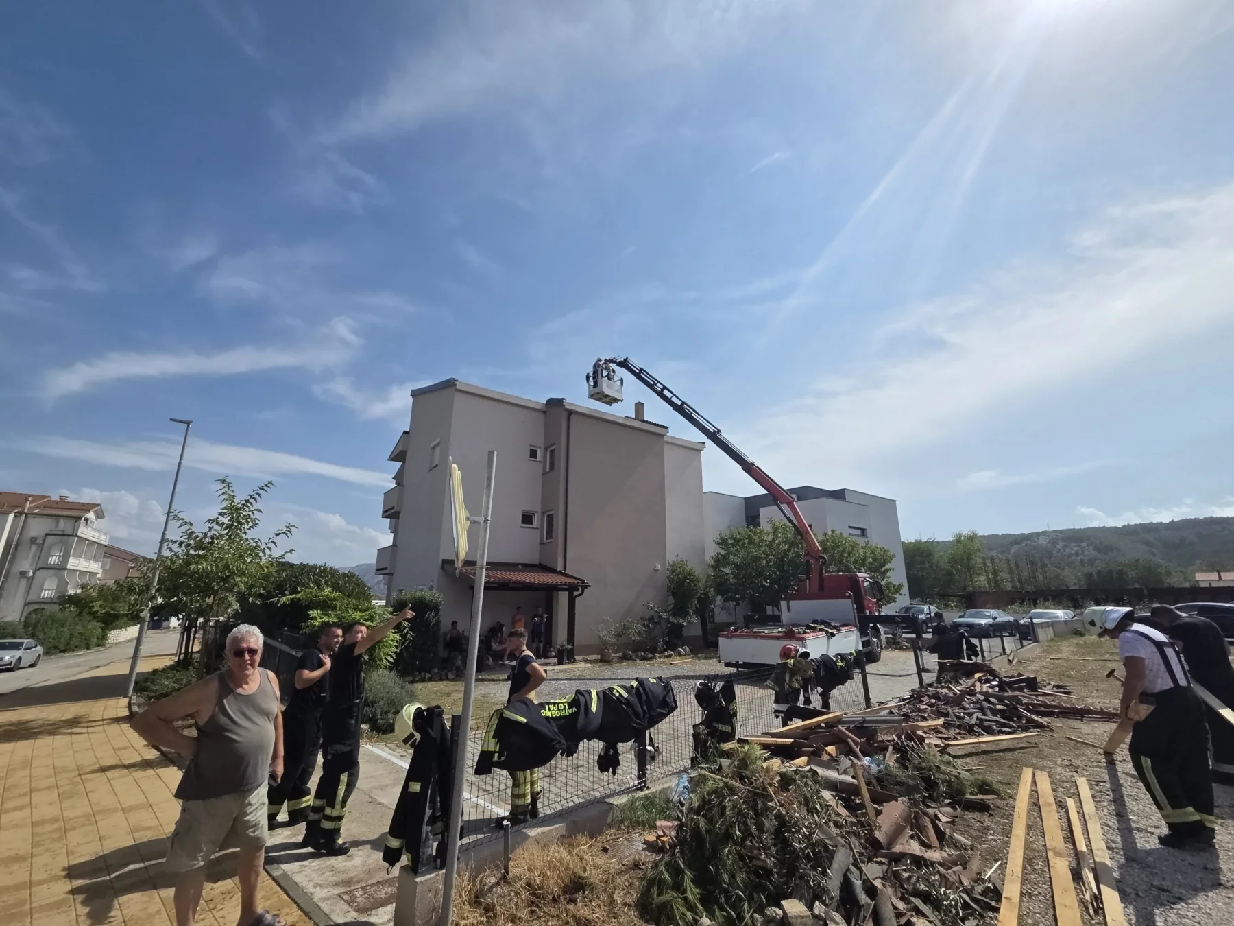 Feuerwehrleute und ein Hubrettungsfahrzeug bei der Sicherung eines sturmgeschädigten Gebäudes in Lopar am 21. August 2026