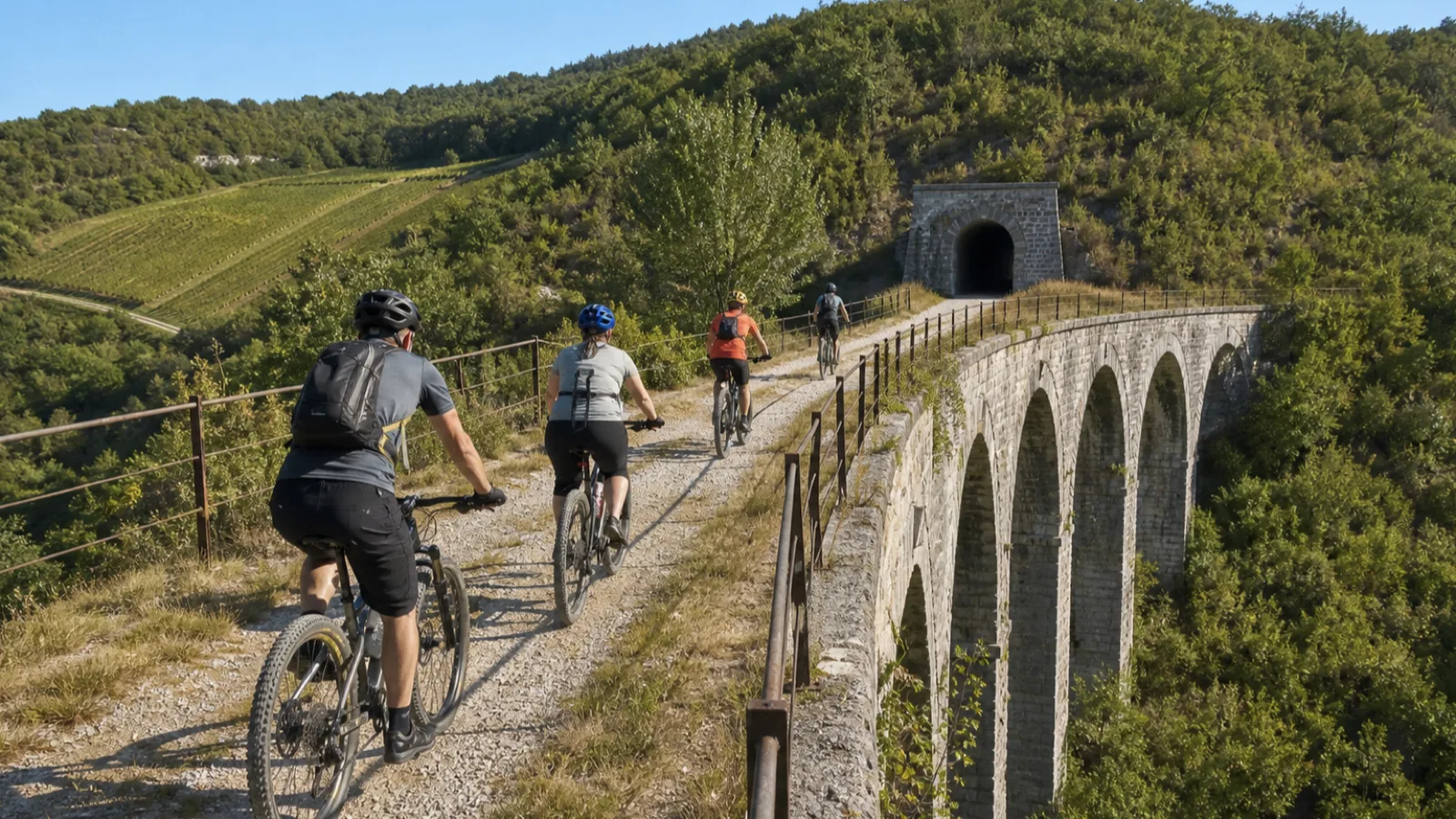 Mountainbiker fahren auf der historischen Parenzana-Trasse über ein Steinviadukt