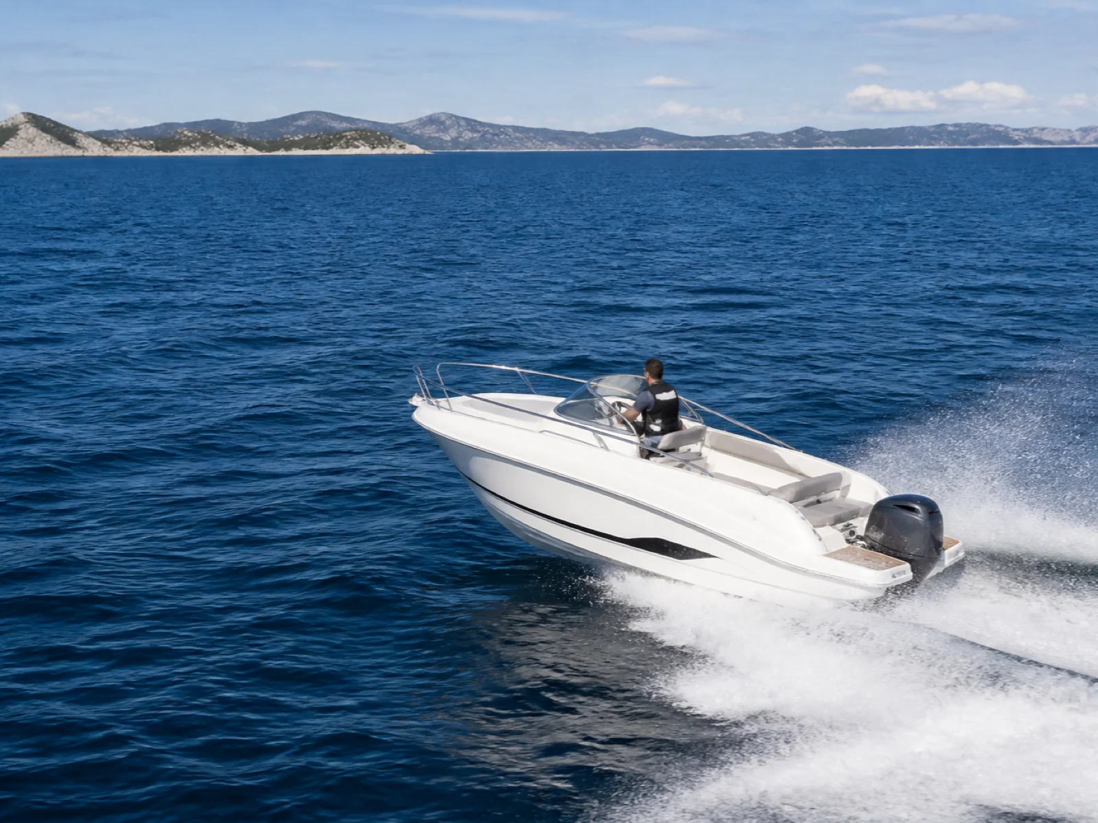 Motorboot fährt in klarer Gleitfahrt auf der offenen Adria mit weit entfernter kroatischer Küste