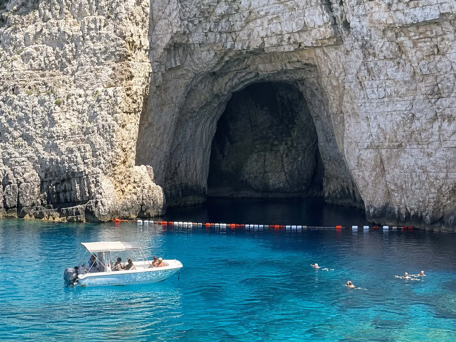 Eine Bojenbarriere hält ein Motorboot vor dem Eingang einer dalmatinischen Meereshöhle zurück