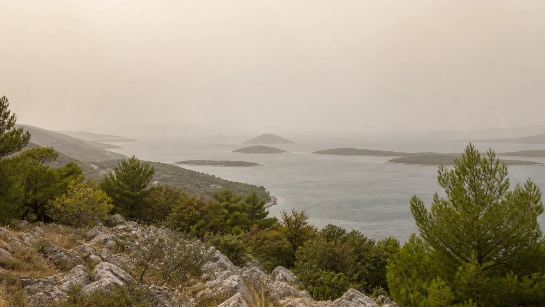Mineralstaub trübt die Fernsicht über Meer und Inseln an Kroatiens Adriaküste