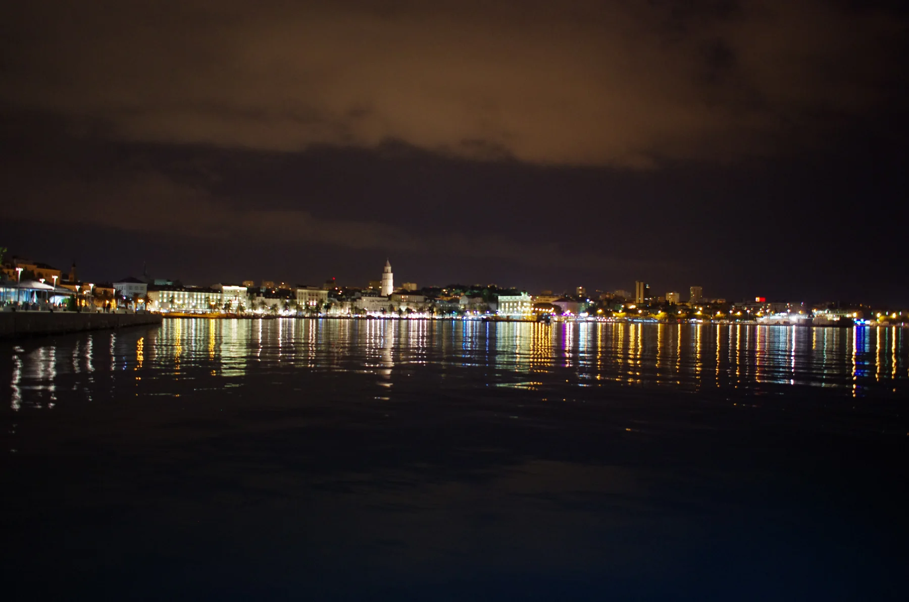 Nächtlicher Blick über das Wasser auf die beleuchtete Riva und Altstadt von Split